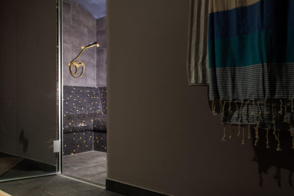 Entrée d'un hammam privé réalisé en mosaïque. Porte du hammam vitrée