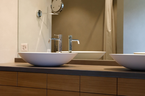 Mobilier de salle de bains en bois et lavabo blanc pour une salle de bain rénovée à Lutry.
