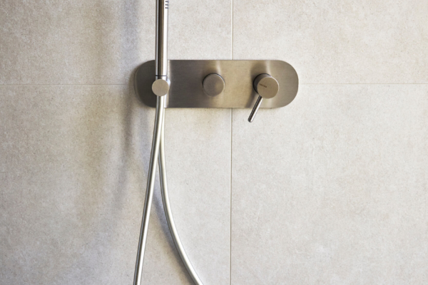 Détail sur l'installation sanitaire et le carrelage dans une salle de bain rénovée à Vevey.