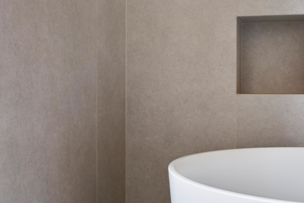 Zoom sur l'angle de deux murs d'une salle de bain rénovée à Vevey