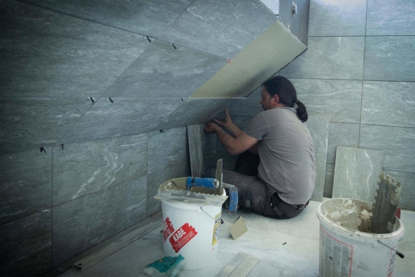 Pose de carrelage contre le surplomb d'un bassin de piscine à Belmont-sur-Lausanne