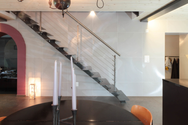 Escalier en métal. Carrelage blanc grand format au mur