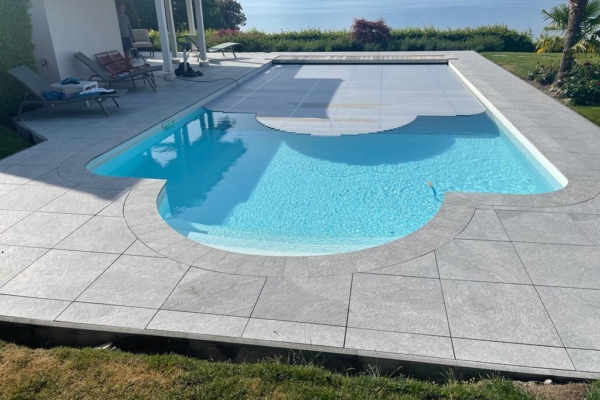 Terrasse en carrelage pour une piscine. Vue entière de la piscine