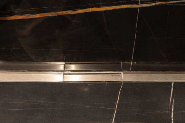 Evacuation d'eau dans douche italienne avec carrelage imitation marbre noire