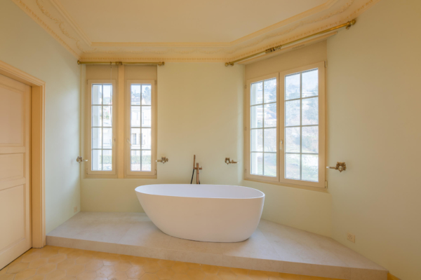 Baignoire dans chambre à coucher avec des murs vert pâle