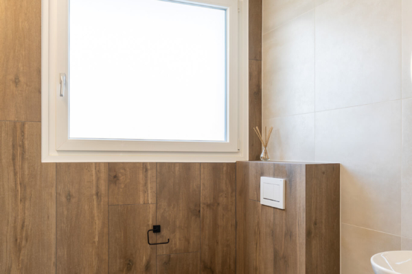 Mur et sol avec carrelage imitation bois, sur autre mur carrelage gris