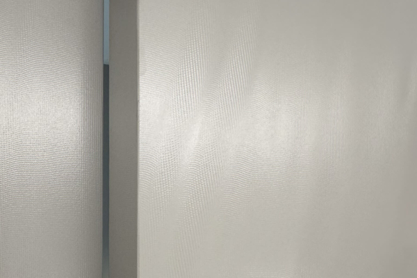 mur texturé avec carrelage Iris Ceramica Luce gris avec éclairage doux dans la salle de bains, créant une ambiance sereine, rénovation à Nyon