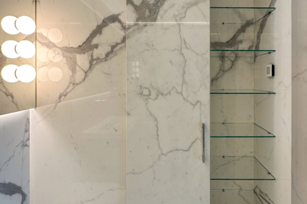 Porte d'armoire ouverte de salle de bains réalisé en carrelage imitation marbre calacatta