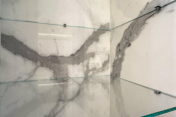 Vue rapprochée de l'intérieur d'une armoire réalisée avec des carreaux de mur en imitation marbre Calacatta de Graniti Fiandre, avec détails des veines grises, installés dans une salle de bains rénovée à Nyon