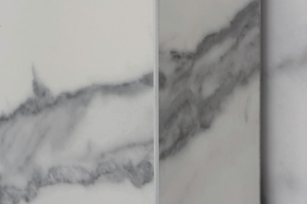 Vue rapprochée de coupe à l'onglet de carreaux de mur en imitation marbre Calacatta de Graniti Fiandre, avec détails des veines grises, installés dans une salle de bains rénovée à Nyon